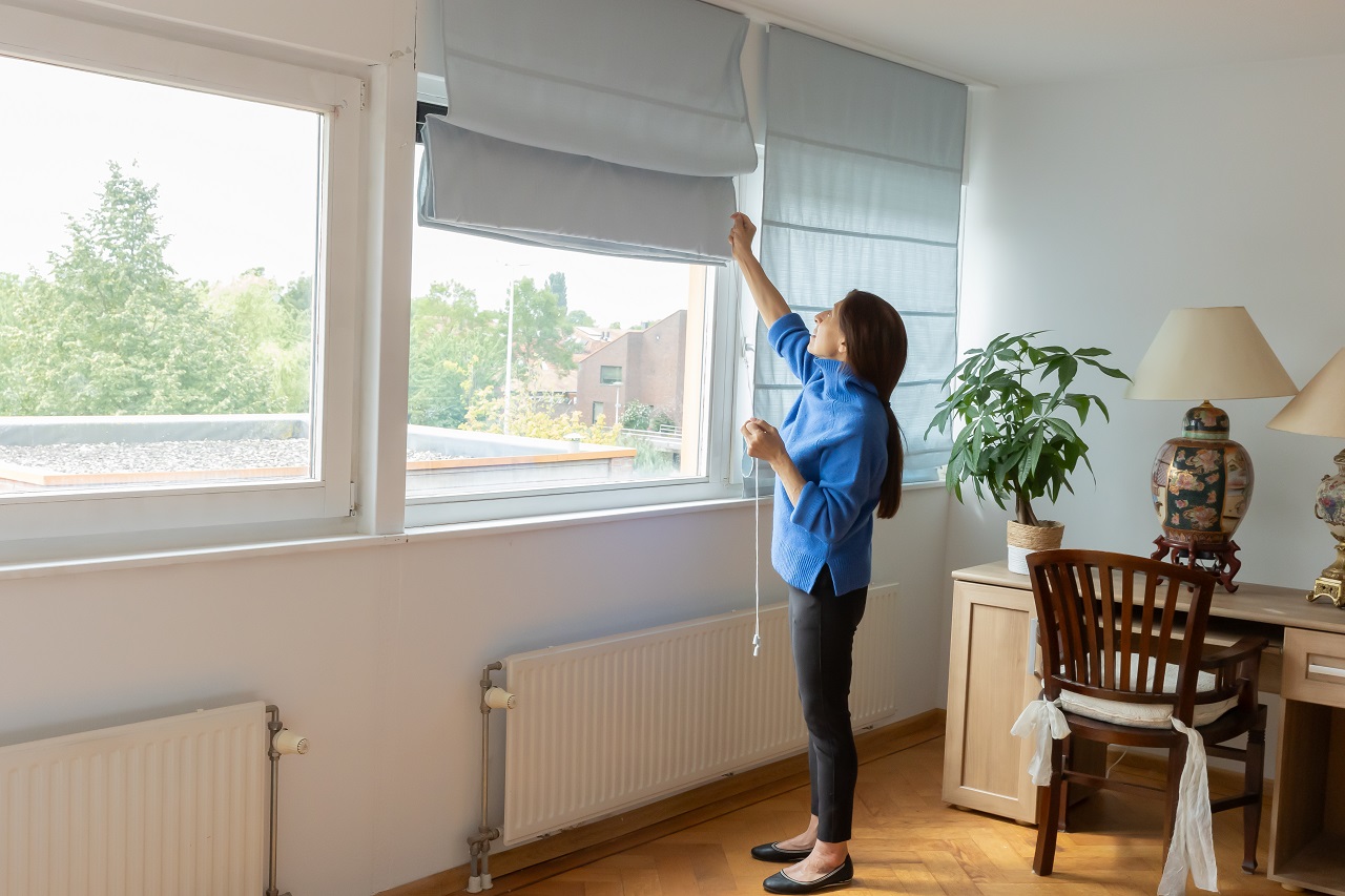 Iemand doet de gordijnen dicht.